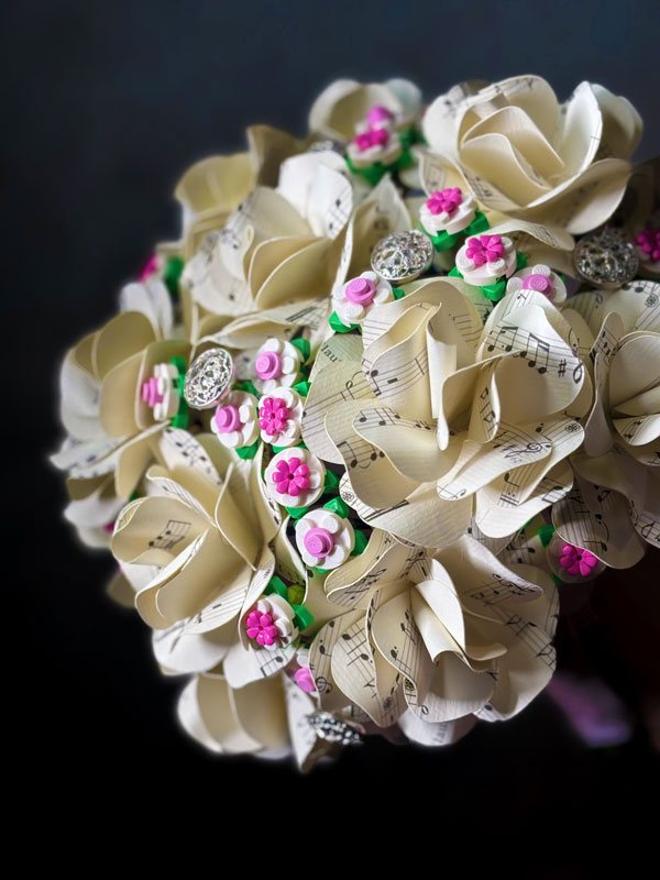 Dettaglio rose di carta spartito musicale bouquet sposa artigianale