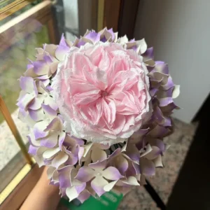 Foto dall'altro del bouquet romantico con ortensie e rosa inglese in carta, fatta dalla cliente a pacco appena arrivato